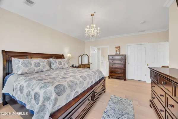 a spacious bedroom with a bed and a chandelier