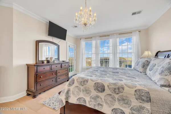 a spacious bedroom with a large bed and a chandelier
