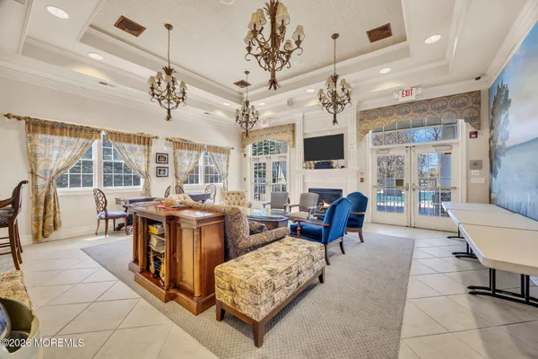 a living room with furniture a chandelier and a flat screen tv