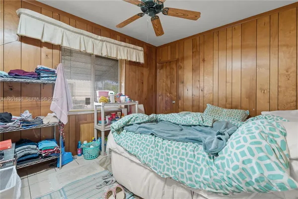 a bedroom with a bed dresser and a flat tv screen