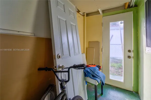 a view of a hallway with wooden floor and a bathroom