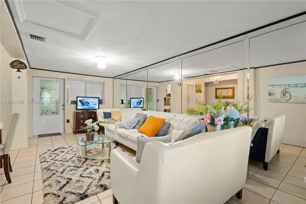 a living room with furniture a rug and a floor to ceiling window