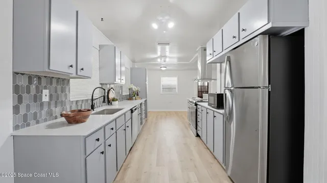 a kitchen with sink a refrigerator and cabinets