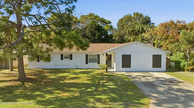 a front view of a house with yard and trees