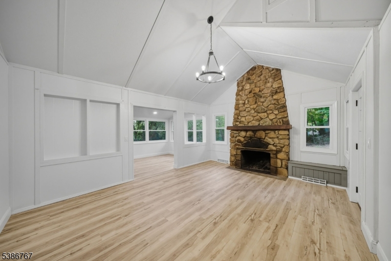 a view of empty room with wooden floor fireplace and windows