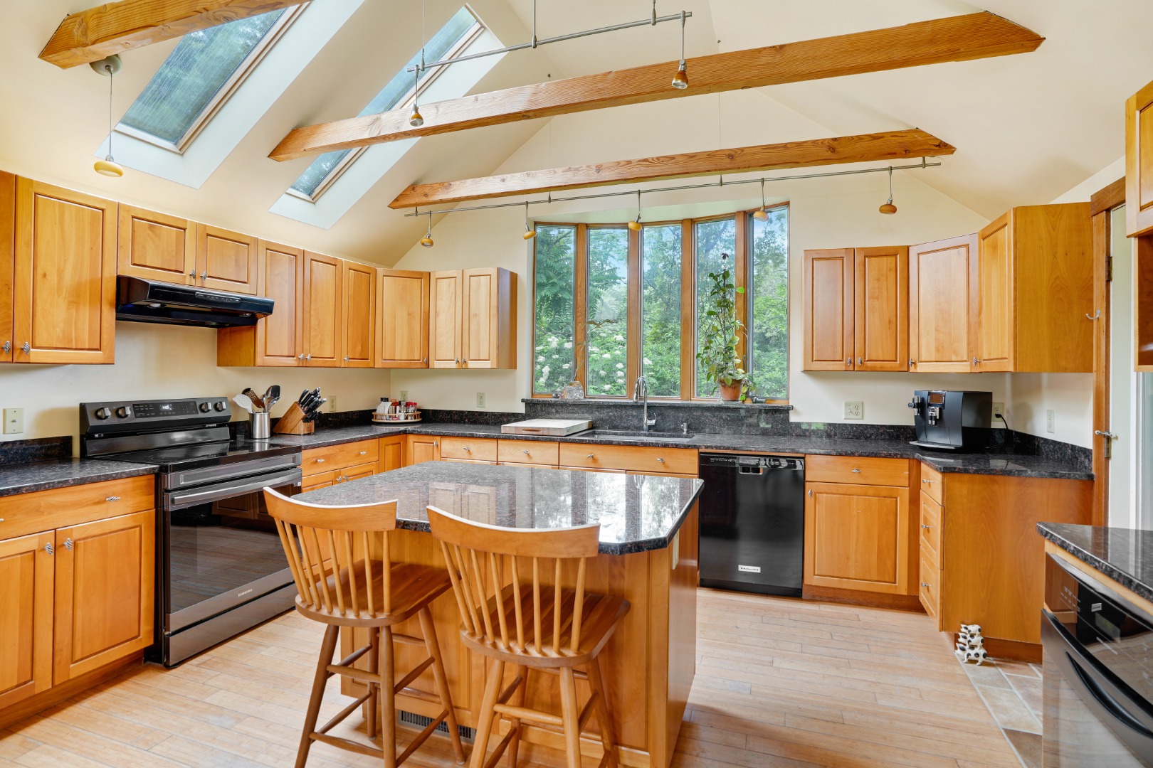 174 Middle Road Chilmark, MA 02535 - Photo 4 of 40 a kitchen with stainless steel appliances granite countertop wooden floor a stove a sink dishwasher and cabinets with wooden floor