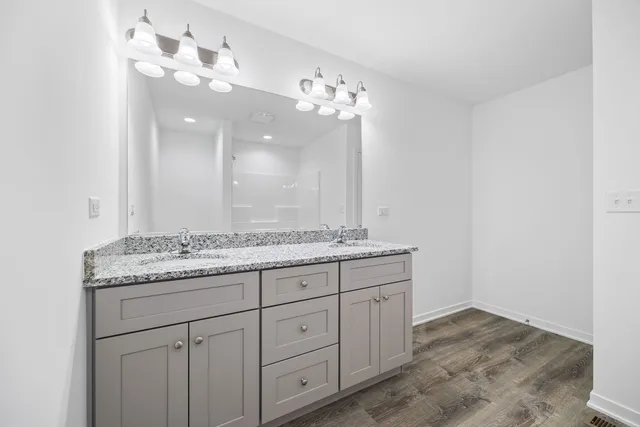 a bathroom with a granite countertop sink a large mirror and a vanity