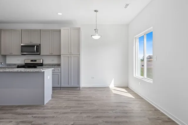 a kitchen with kitchen island white cabinets and refrigerator