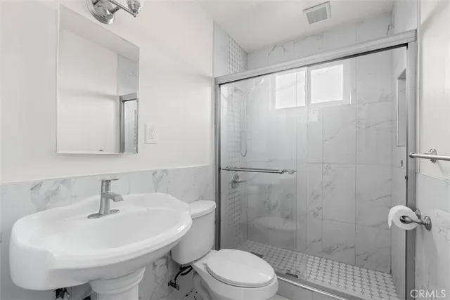 a bathroom with a sink a toilet and shower