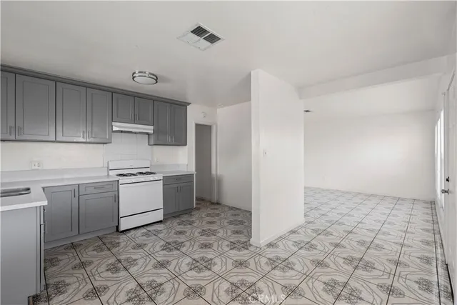 a kitchen with granite countertop a stove a sink and a refrigerator