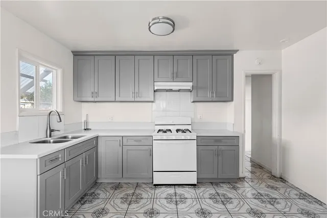 a kitchen with a stove sink and cabinets