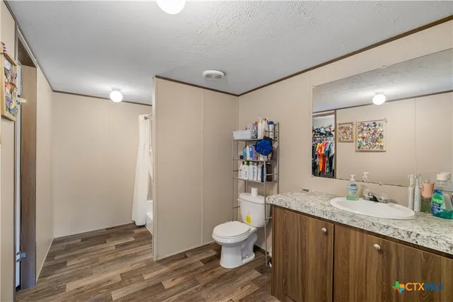 a bathroom with a granite countertop sink toilet and shower