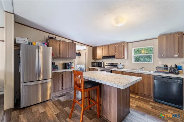a kitchen with stainless steel appliances granite countertop a refrigerator stove microwave and sink