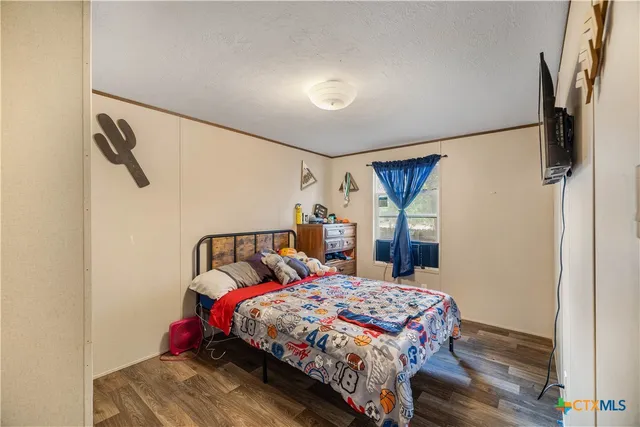 a bedroom with a bed a mirror and a window