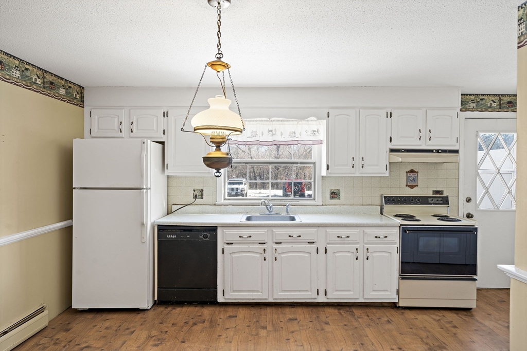 a kitchen with kitchen island white cabinets and refrigerator