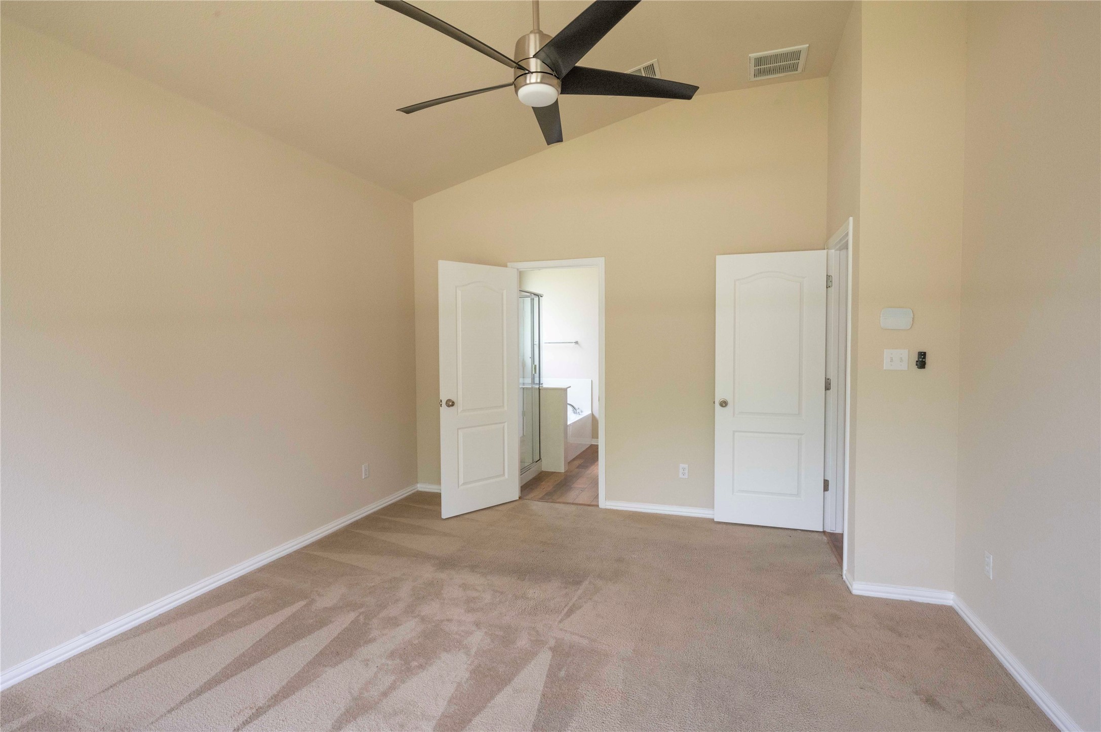 2070 Intrepid Drive Buda, TX 78610 - Photo 10 of 31 A vaulted ceiling and a ceiling fan create an airy atmosphere in this spacious primary bedroom.