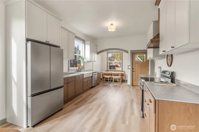 a kitchen with a refrigerator a sink and white cabinets