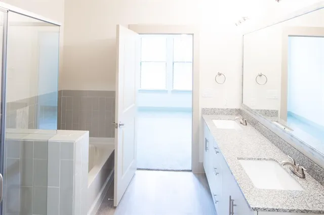a bathroom with a tub sink and mirror