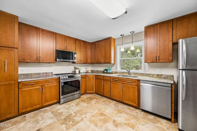 a kitchen with stainless steel appliances granite countertop a refrigerator stove a sink and dishwasher
