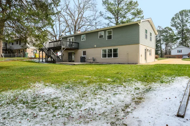 a view of a house with a large tree and a yard