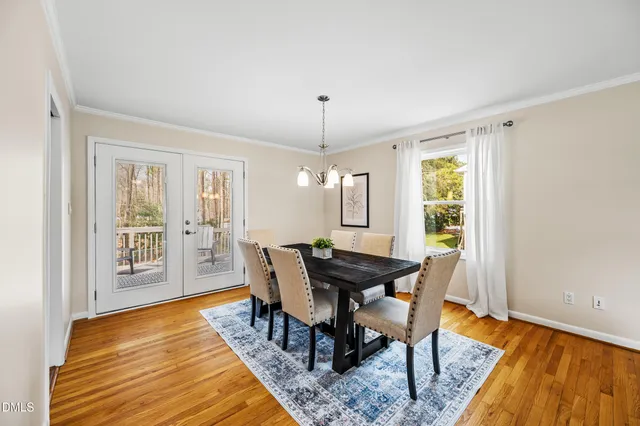 a dining room with wooden floor and large window