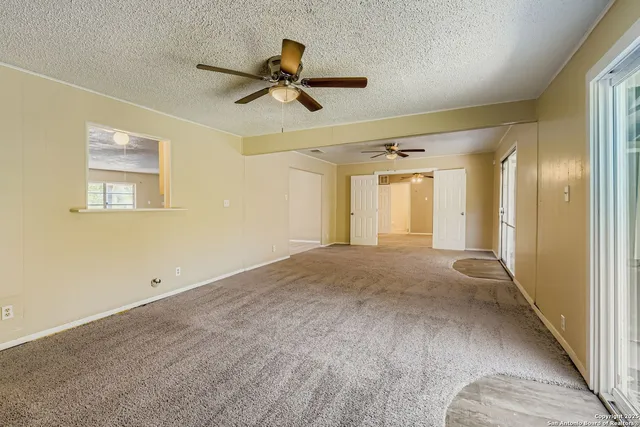 a view of a livingroom with a chandelier fan and a window