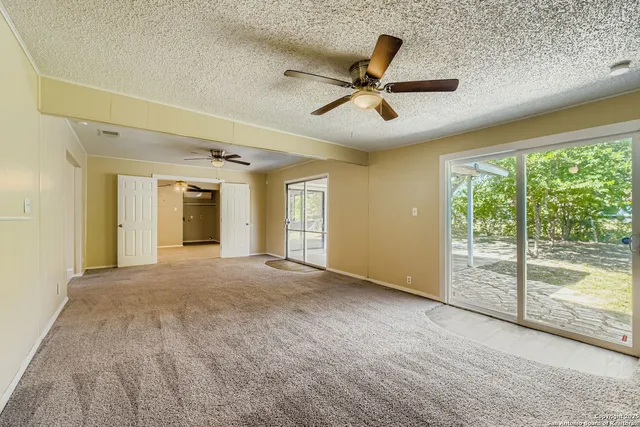 a view of a livingroom with a ceiling fan and window