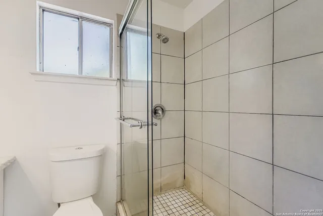 a bathroom with a shower toilet and sink