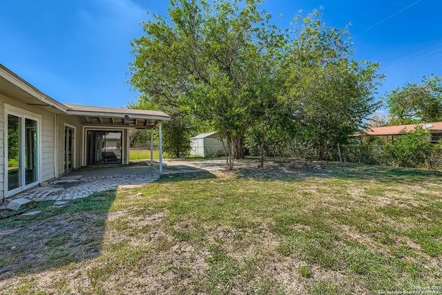 a view of a house with backyard and sitting area