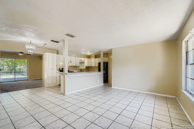 a large white kitchen with a stove a sink dishwasher and a refrigerator with white cabinets