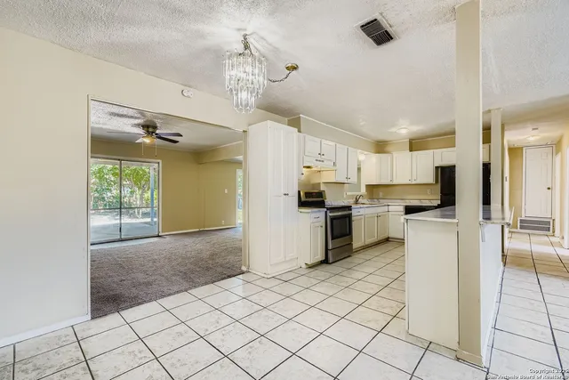 a kitchen with a refrigerator a stove top oven and cabinets