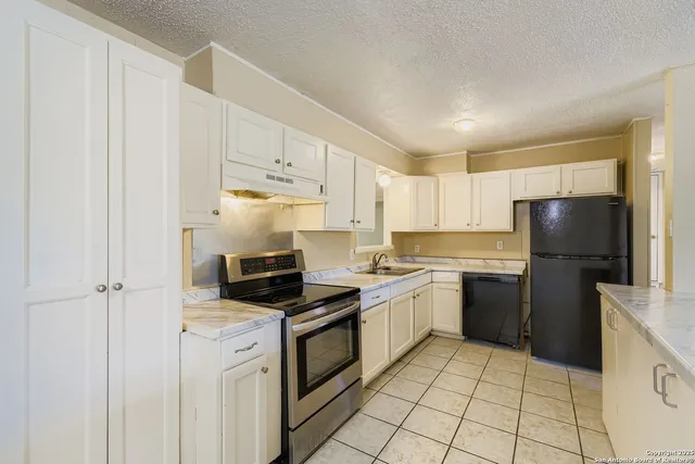 a kitchen with a sink a refrigerator and cabinets