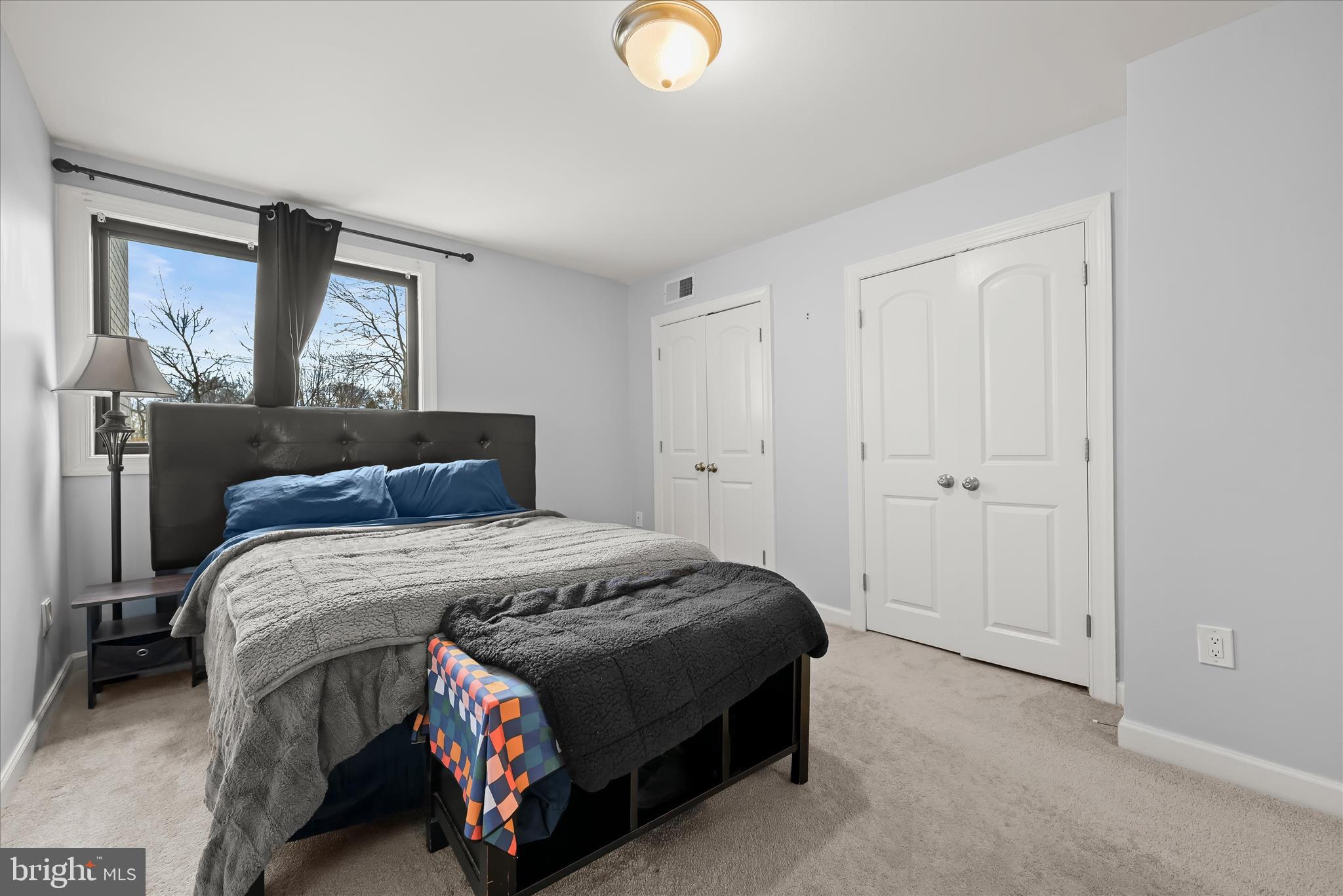 10851-10859 Amherst Avenue, Unit 202 Silver Spring, MD 20902 - Photo 3 of 32 a bedroom with a bed and lamp