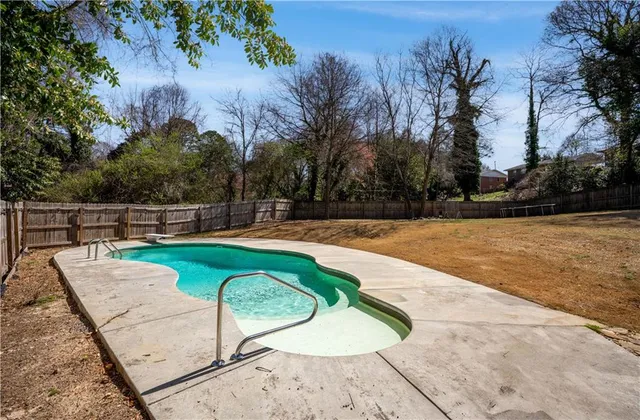 a view of a swimming pool with a yard and seating space