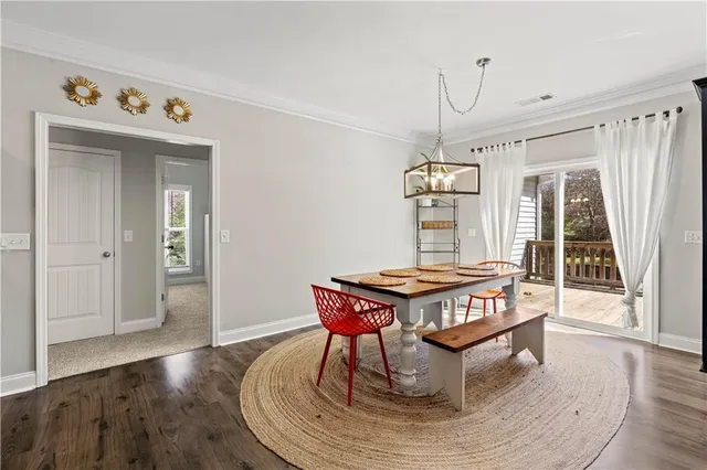 a living room with a table chairs and wooden floor