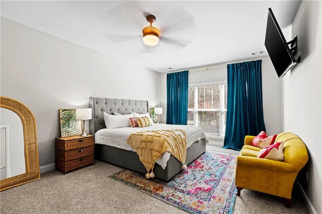 a bedroom with a bed a couch and a chandelier