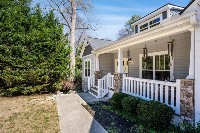 a view of a house with a small yard and wooden fence