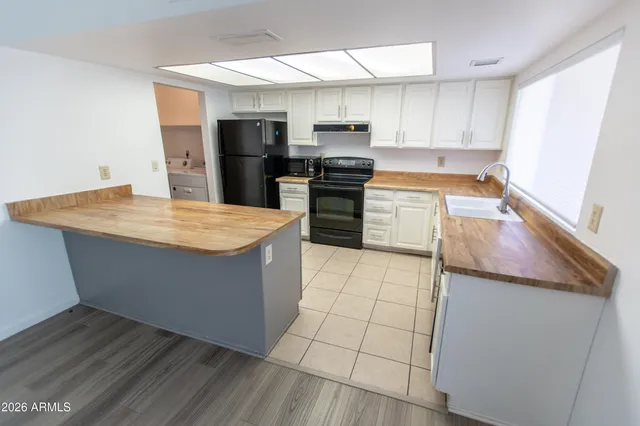 a kitchen with white cabinets and refrigerator