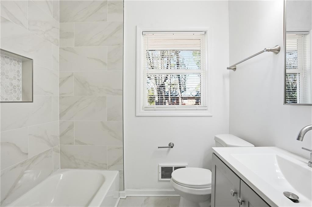 3130 Gay Drive Decatur, GA 30032 - Photo 18 of 28 a bathroom with a granite countertop toilet a sink and a bathtub