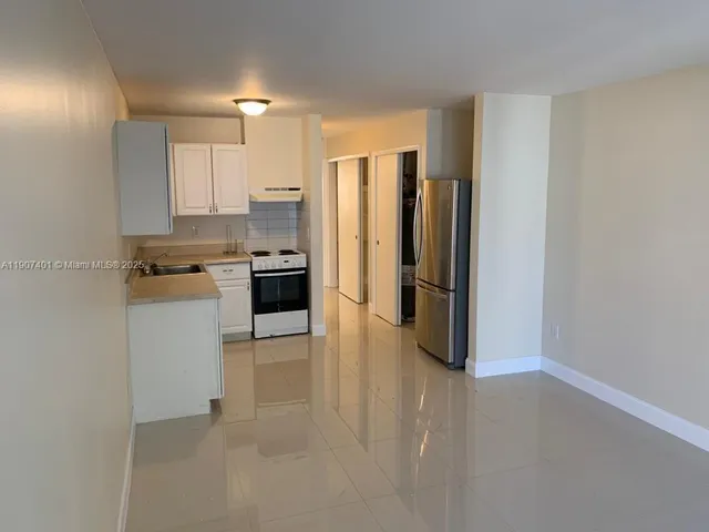 a metallic refrigerator freezer and a stove sitting inside of a kitchen
