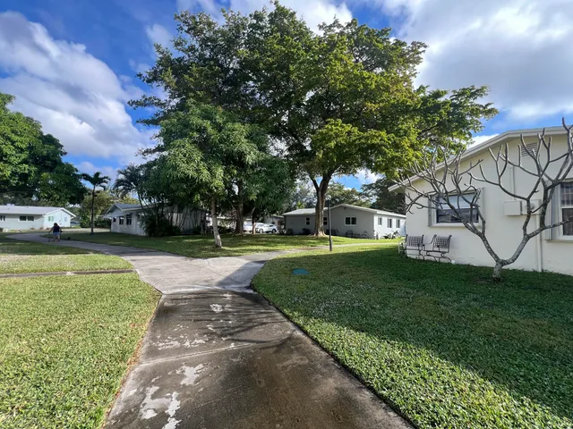 a view of a fountain in front of a house with a big yard