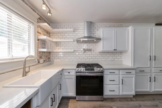 a kitchen with stainless steel appliances a sink stove and cabinets