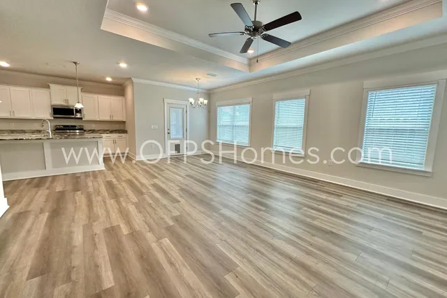 a view of a kitchen with kitchen island a sink wooden floor and stainless steel appliances