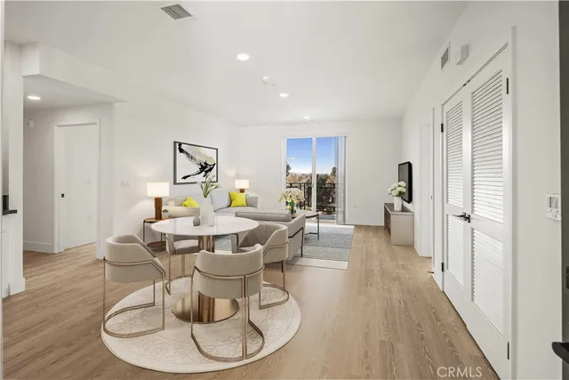 a dining room with wooden floor a glass table and chairs