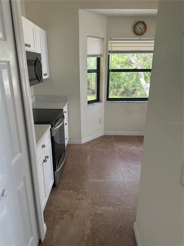 a living room with a fireplace furniture a flat screen tv and a window