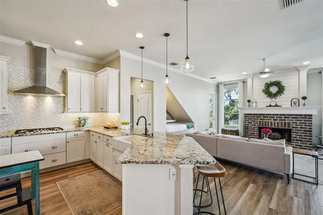 a kitchen with kitchen island granite countertop a table chairs stove and wooden cabinets