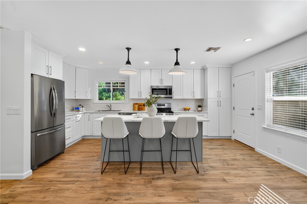 7582 McGroarty Terrace Los Angeles, CA 91042 - Photo 33 of 47 a kitchen with stainless steel appliances granite countertop a dining table chairs refrigerator and microwave