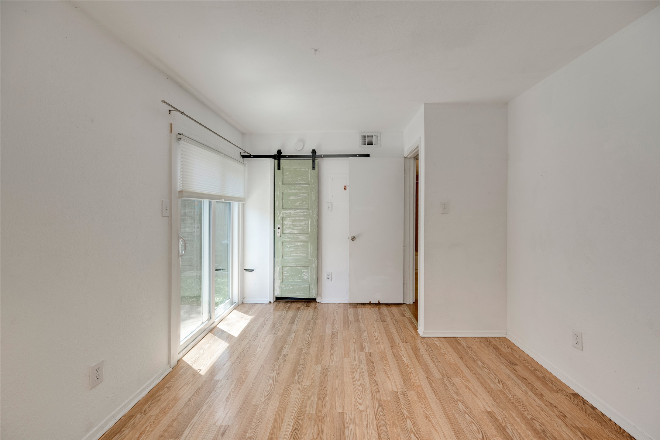 3627 Menchaca Road, Unit 108 Austin, TX 78704 - Photo 14 of 24 Gleaming hardwood floors and a sliding glass door define this versatile interior space.