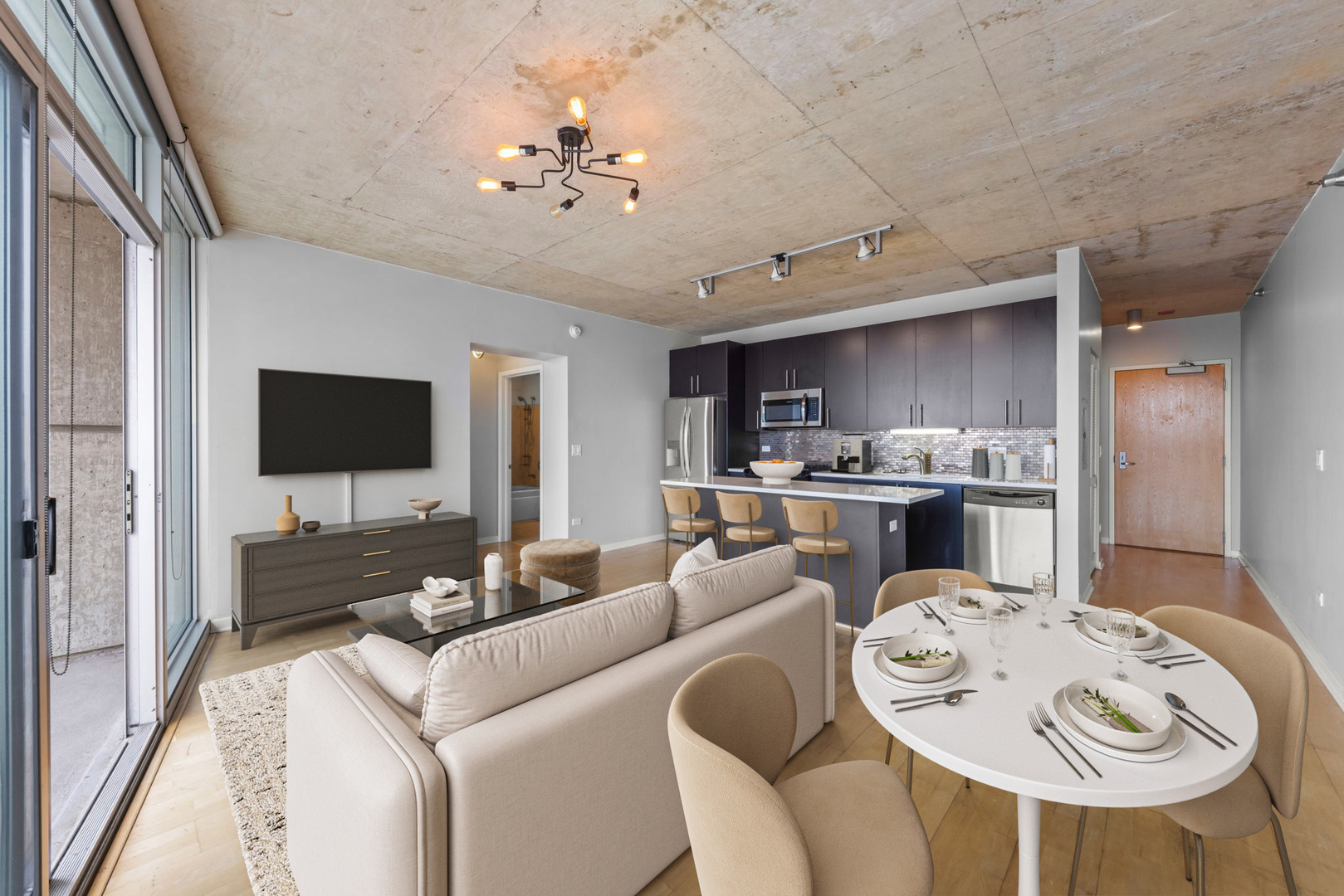 611 South Wells Street, Unit 2402 Chicago, IL 60607 - Photo 4 of 33 a living room with furniture kitchen view and a flat screen tv