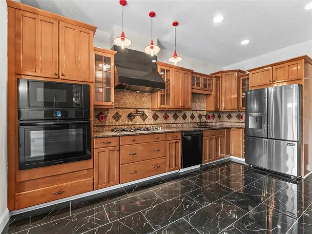 a kitchen with granite countertop stainless steel appliances and wooden cabinets